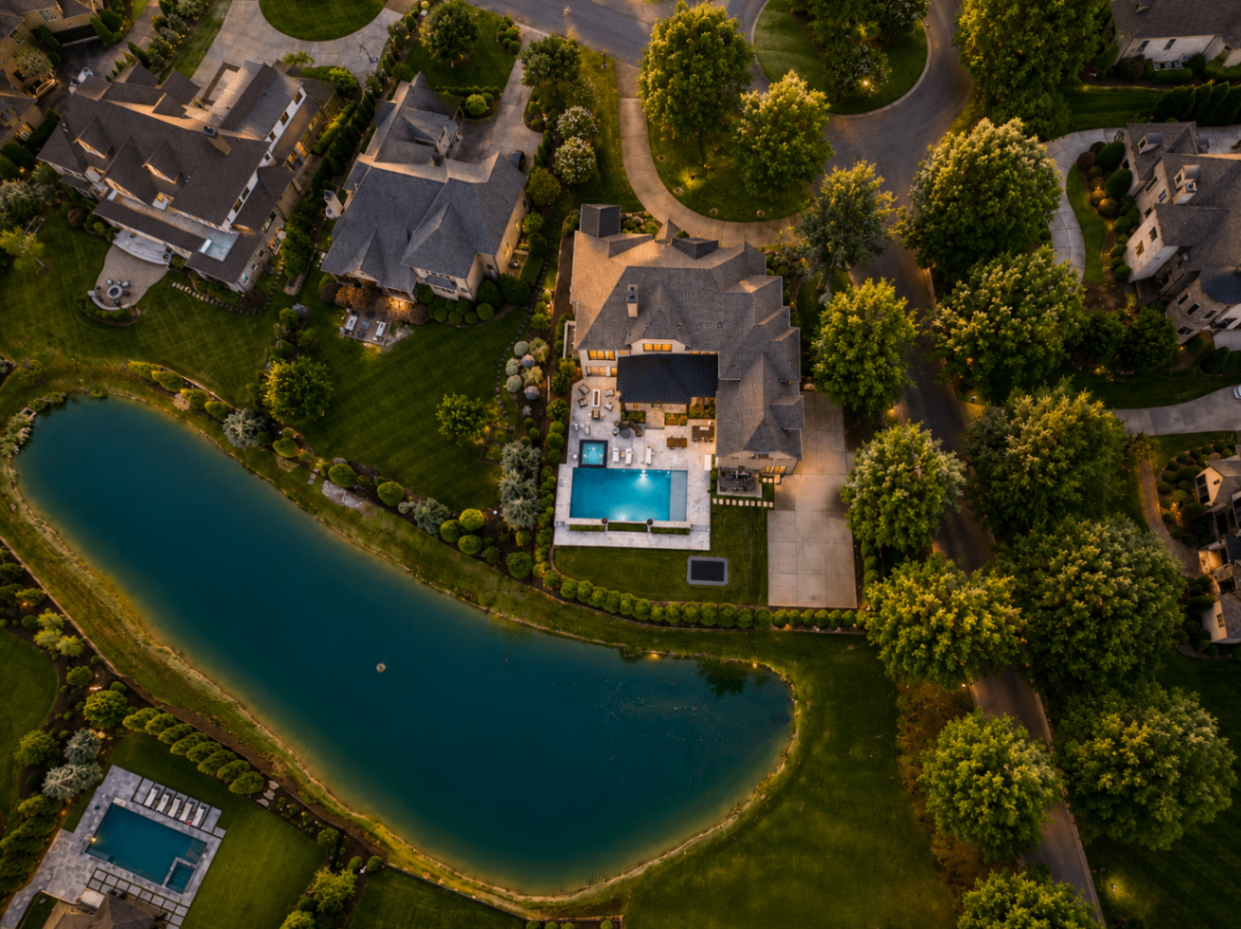 Aerial overhead of a Skyecroft estate with pool and adjacent private pond
